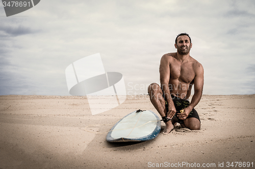 Image of Surfer tying his surfboard\'s leach