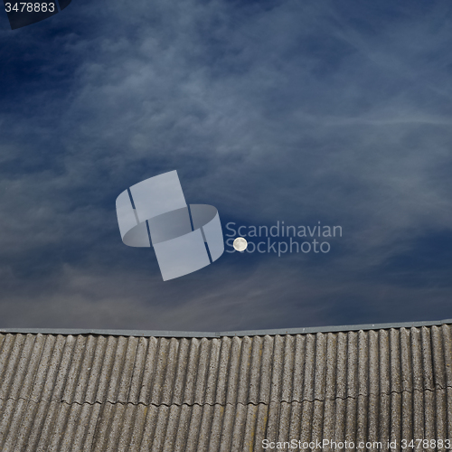 Image of tiled top of the roof and cloudy blue sky