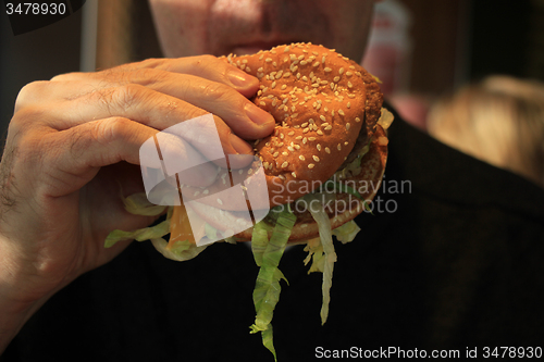 Image of Man holding a hamburger