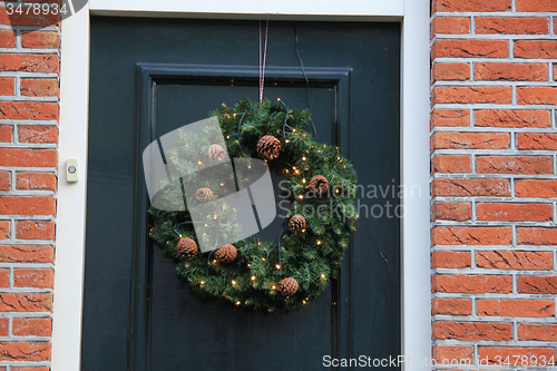 Image of Classic christmas wreath with decorations on a door