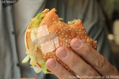 Image of Man holding a hamburger