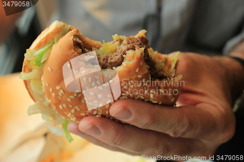 Image of Man holding a hamburger