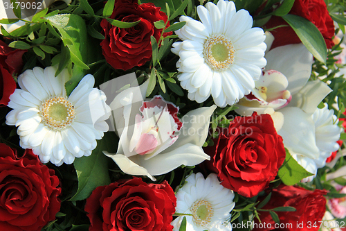 Image of Cymbidium orchids, red roses and white gerberas