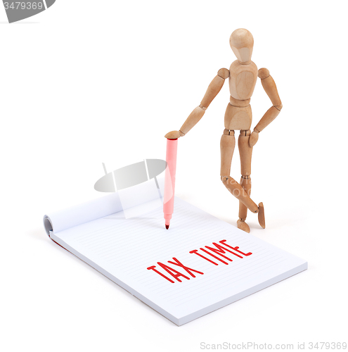 Image of Wooden mannequin writing - Tax time