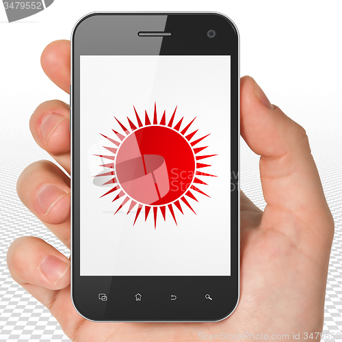 Image of Tourism concept: Hand Holding Smartphone with Sun on display