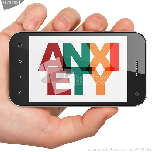 Image of Medicine concept: Hand Holding Smartphone with Anxiety on  display