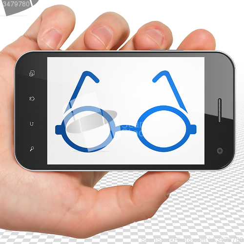Image of Studying concept: Hand Holding Smartphone with Glasses on display