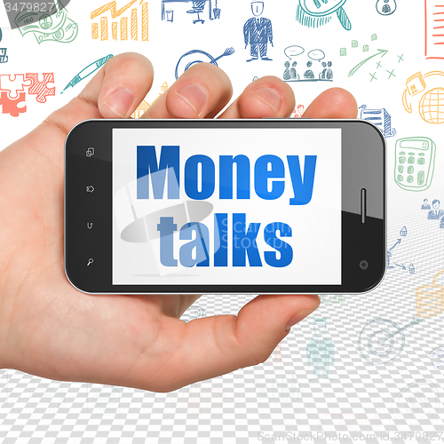 Image of Finance concept: Hand Holding Smartphone with Money Talks on display