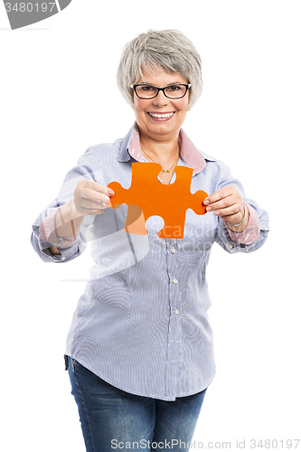 Image of Elderly woman holding a puzzle piece