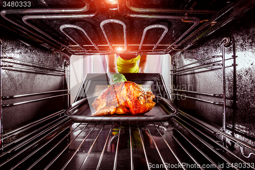 Image of Cooking chicken in the oven at home.