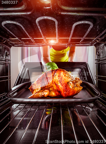 Image of Cooking chicken in the oven at home.