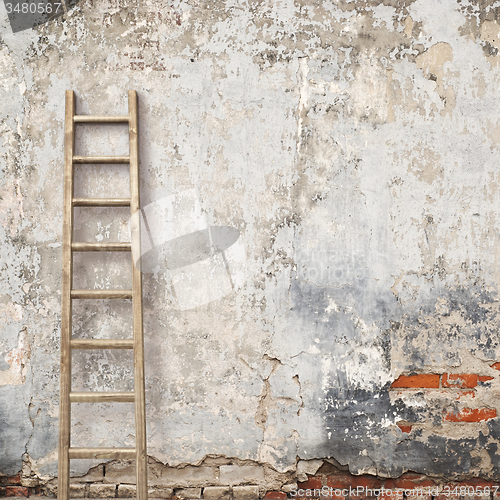 Image of weathered stucco wall with wooden ladder