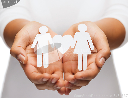 Image of womans hands with paper couple