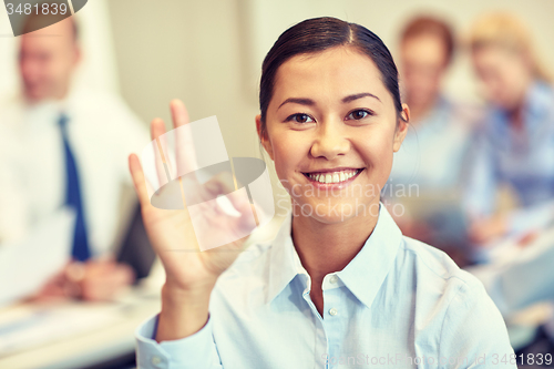 Image of group of smiling businesspeople meeting in office