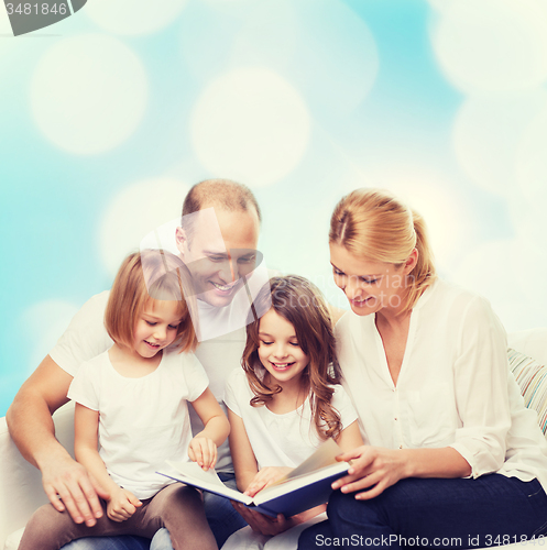 Image of happy family with book at home