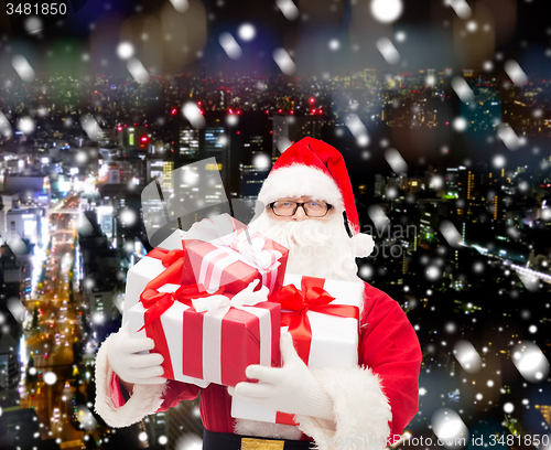 Image of man in costume of santa claus with gift boxes