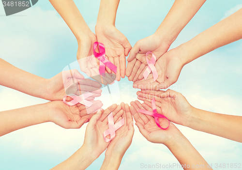 Image of close up of hands with cancer awareness symbol