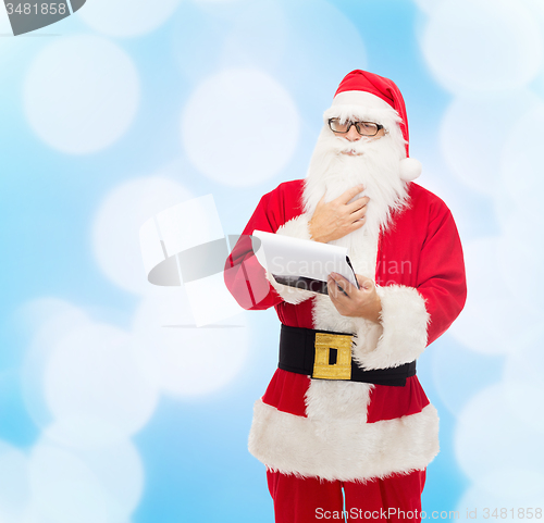 Image of man in costume of santa claus with notepad