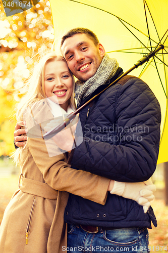 Image of smiling couple hugging in autumn park