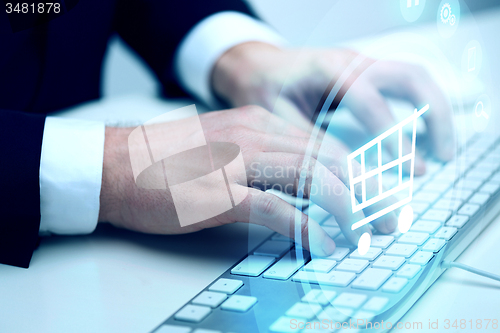 Image of close up of hands with  keyboard and shopping cart