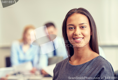Image of group of smiling businesspeople meeting in office