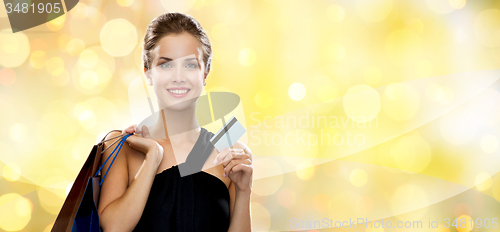 Image of smiling woman with shopping bags and plastic card