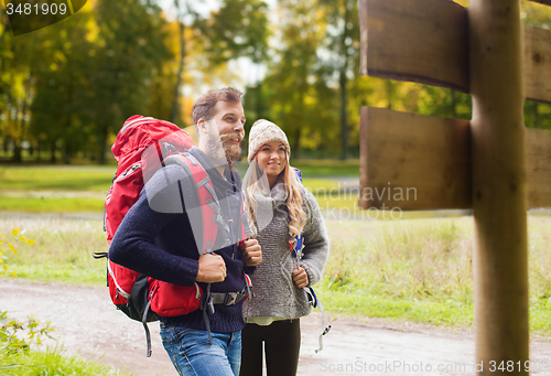 Image of smiling couple with backpacks hiking