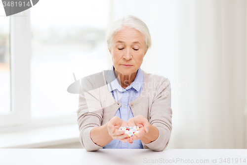 Image of senior woman with medicine at home