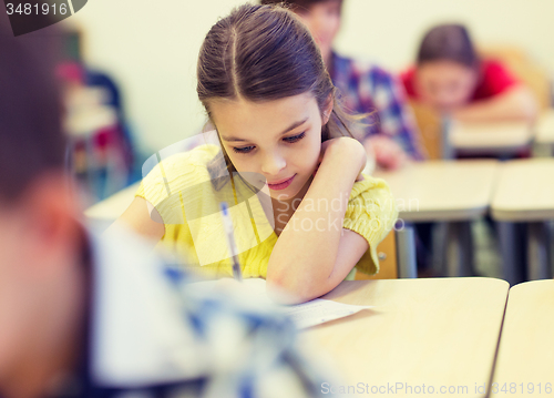 Image of group of school kids writing test in classroom