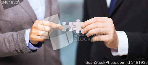 Image of businessman and businesswoman with puzzle pieces