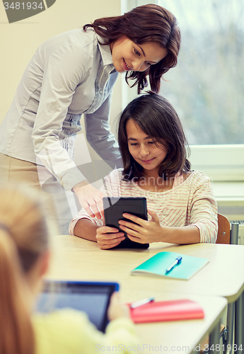 Image of little girl with teacher and tablet pc at school