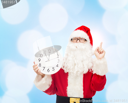 Image of man in costume of santa claus with clock