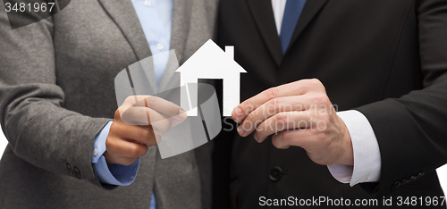 Image of businessman and businesswoman holding white house