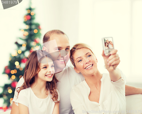 Image of happy family with camera at home