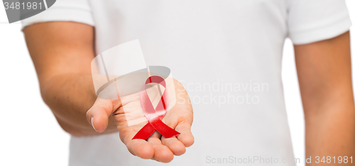 Image of hand with red aids or hiv awareness ribbon