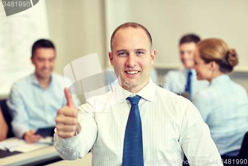 Image of group of smiling businesspeople meeting in office