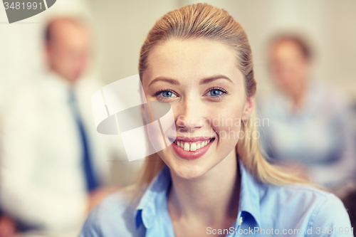 Image of group of smiling businesspeople meeting in office