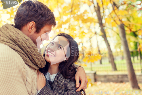 Image of smiling couple hugging in autumn park