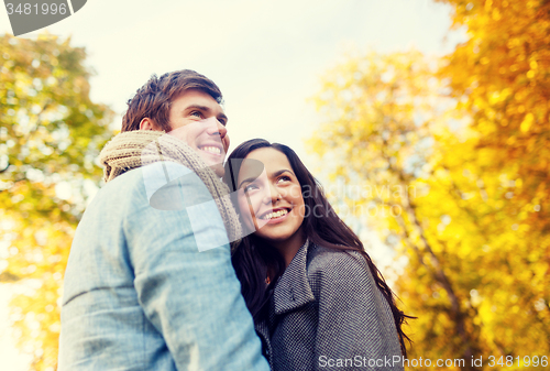 Image of smiling couple hugging in autumn park