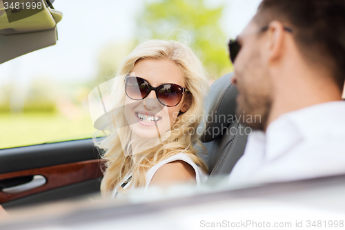 Image of happy man and woman driving in cabriolet car