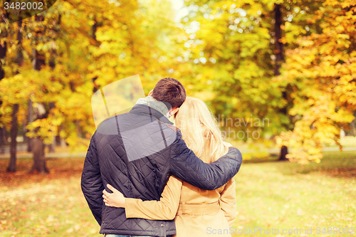 Image of couple hugging in autumn park from back