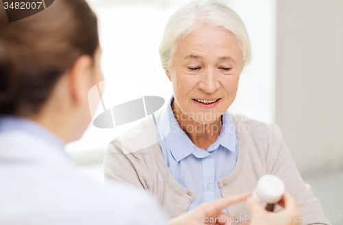 Image of doctor with medicine and senior woman at hospital