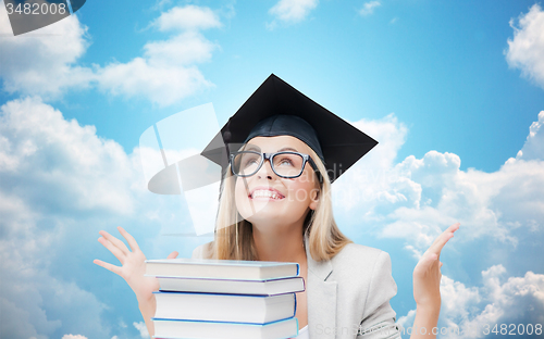 Image of happy student girl in bachelor cap with books
