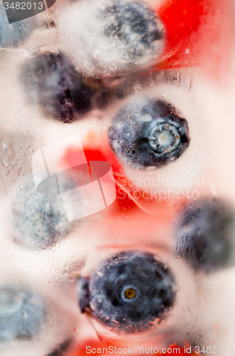 Image of close up of fruit water with ice cubes over glass