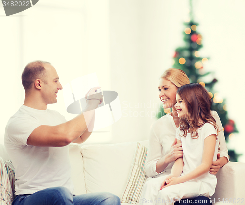 Image of happy family with camera at home