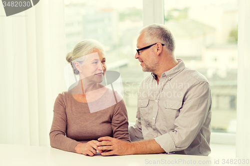 Image of happy senior couple sitting on sofa at home