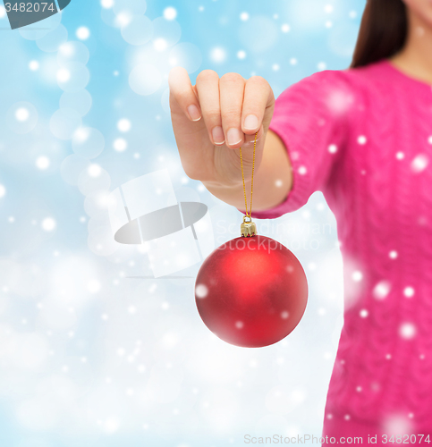 Image of close up of woman in sweater with christmas ball