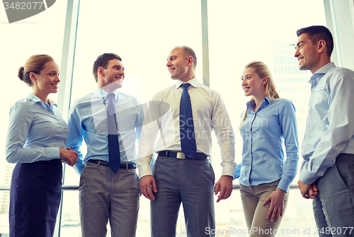 Image of smiling businesspeople meeting in office