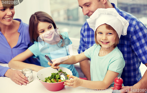 Image of happy family with two kids cooking at home