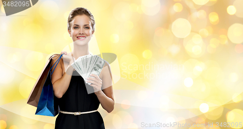 Image of smiling woman with shopping bags and dollar money